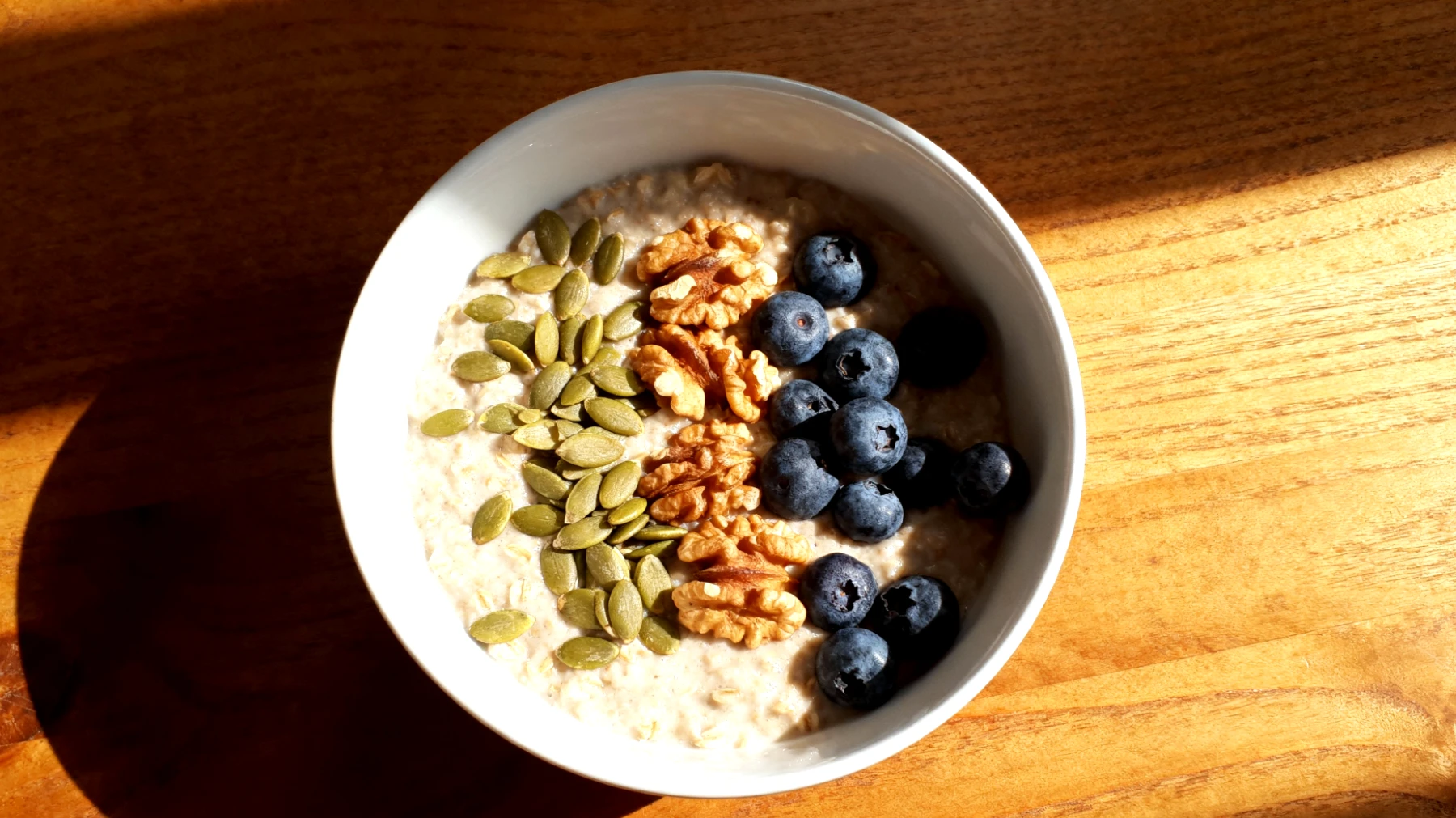 Porridge di avena con semi di zucca, noci e mirtilli"